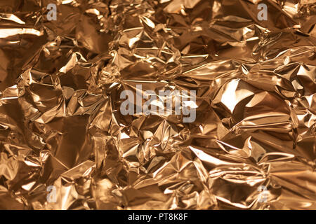 Full frame take of a sheeT of crumpled gold aluminum foil background Stock Photo