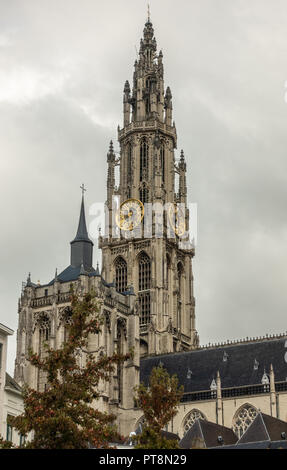 Antwerp, Belgium - September 24, 2018: Closeup of Towers and nave of Onze-Lieve-Vrouwe Cathedral of Our Lady in back under gray cloudy sky. Some green Stock Photo