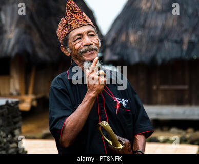 The village chief raises his index finger and smiles during his address in a mountain village near Moni, Flores, Indonesia. Stock Photo
