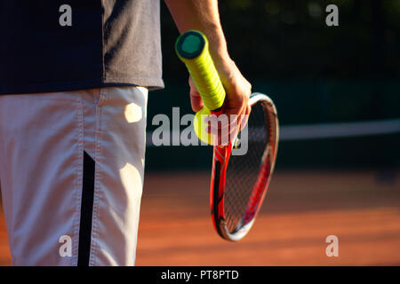 A tennis player prepares to serve a tennis ball during a match Stock Photo