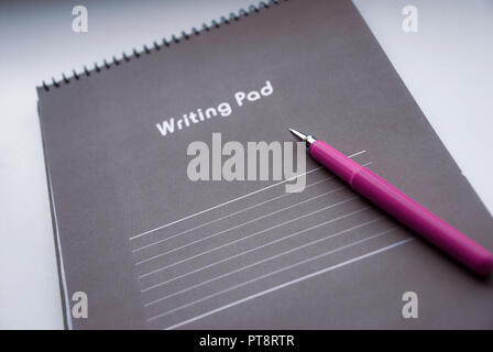 Writing pad with a pen lying on it Stock Photo