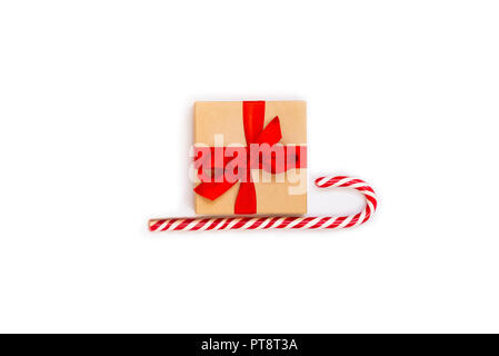 Christmas sledge - a gift box over candy cane on a white background. Abstract christmas concept. Stock Photo