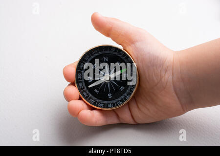 Compass tool in toddler hand on white Stock Photo