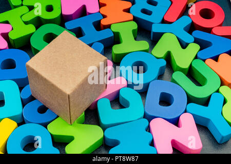 Cardboard box cube and Colorful Letters of Alphabet Stock Photo