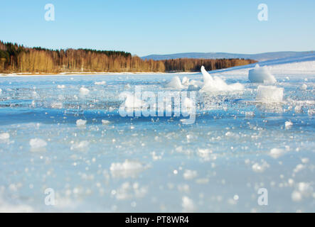 Frozen lake surface with small ice cracks on a sunny day Stock Photo