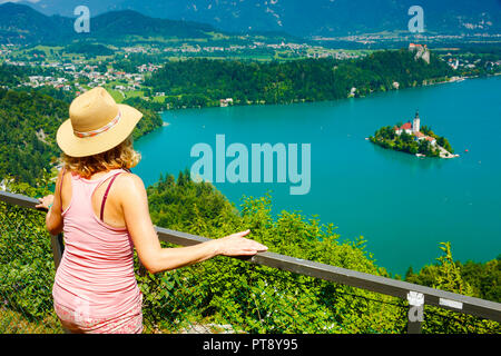 Woman looking a lake landscape from a viewpoint. Stock Photo