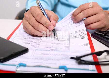 Man is filling form with pen. Picture of form on the clipboard. Stock Photo