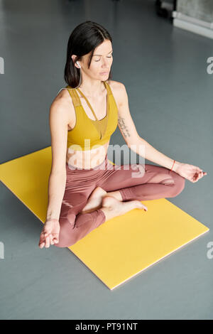Young Woman Meditating in Gym Stock Photo