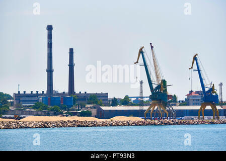 Hoisting cranes in the industrial zone of the port. Stock Photo
