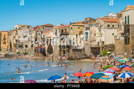 Cefalù waterfront with peole relaxing on a sunny summer day. Sicily, southern Italy. Stock Photo