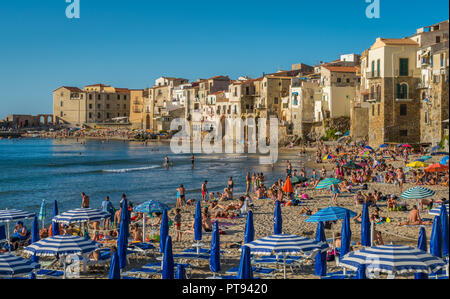 Cefalù waterfront with peole relaxing on a sunny summer day. Sicily, southern Italy. Stock Photo