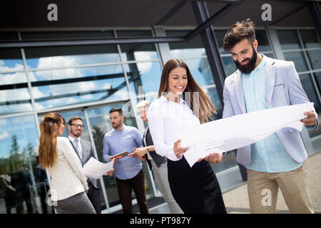 Business people discussing over documents in office lobby. Stock Photo
