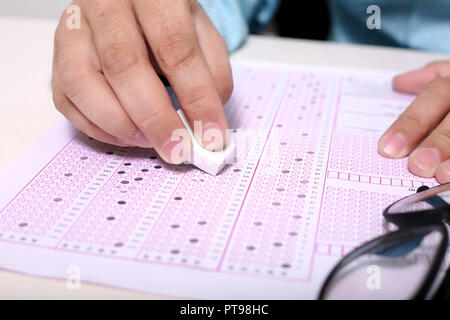 Man hand is erasing filled OMR sheet with eraser Stock Photo - Alamy
