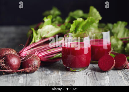 Detox juice with freshly picked bunch of beetroot. Fresh beets on a wooden table. Stock Photo