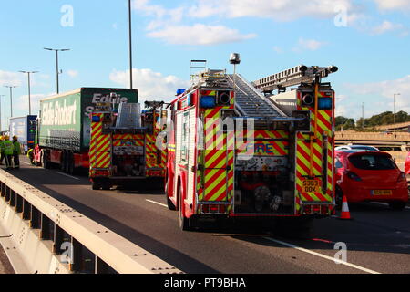 Dennis Fire Engines from West Midlands Fire And Rescue leaving the scene of an accident involving a lorry on the M6 Motorway in Birmingham Stock Photo