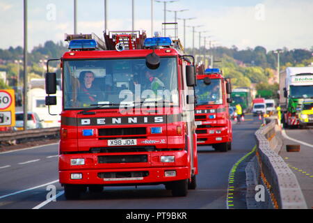 Dennis Fire Engines from West Midlands Fire And Rescue leaving the scene of an accident involving a lorry on the M6 Motorway in Birmingham Stock Photo