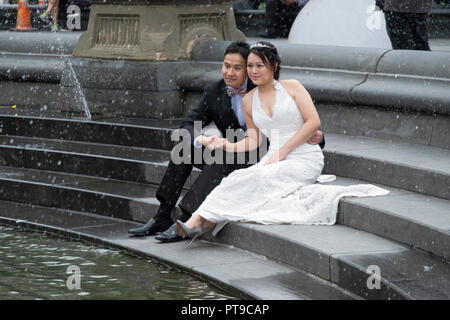 An attractive Asian American couple pose for photos at Washington Square Park in Greenwich Village, New York City. Stock Photo