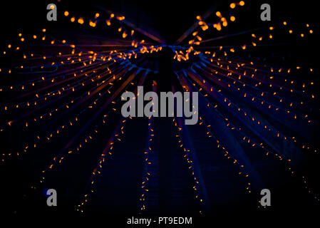 A collection of small little orange lights on the top of a purple ceiling of a tent at a wedding at night in the UK Stock Photo