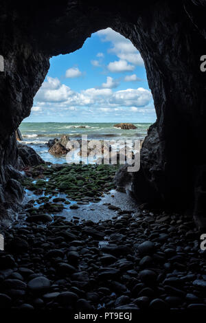 A view out to sea from inside a cave. Stock Photo