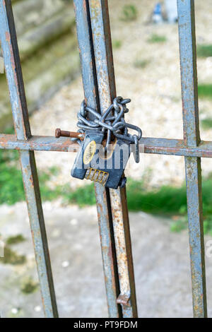 Heavy duty combination padlock with chain on gate Stock Photo