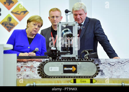 Darmstadt, Hessen, Germany. 08th Oct, 2018. Federal Chancellor Angela Merkel and Hesse's Prime Minister Volker Bouffier (both CDU) observe a rescue robot during a visit to the Technical University. During a demonstration, search and rescue robots from the 'Hector' team are used, which can, for example, search autonomously for buried people. Credit: Uwe Anspach/dpa/Alamy Live News Stock Photo