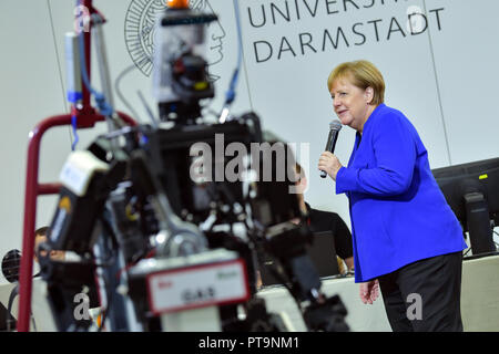 Darmstadt, Hessen, Germany. 08th Oct, 2018. Chancellor Angela Merkel (CDU) stands next to humanoid robot Johnny during a visit to the Technical University. During a demonstration, search and rescue robots from the 'Hector' team are used, which can, for example, search autonomously for buried people. Credit: Uwe Anspach/dpa/Alamy Live News Stock Photo