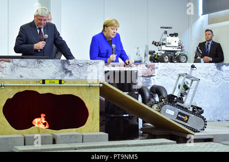 Darmstadt, Hessen, Germany. 08th Oct, 2018. Federal Chancellor Angela Merkel and Hesse's Prime Minister Volker Bouffier (both CDU) observe the journey of a rescue robot during a visit to the Technical University. During a demonstration, search and rescue robots from the 'Hector' team are used, which can, for example, search autonomously for buried people. Credit: Uwe Anspach/dpa/Alamy Live News Stock Photo