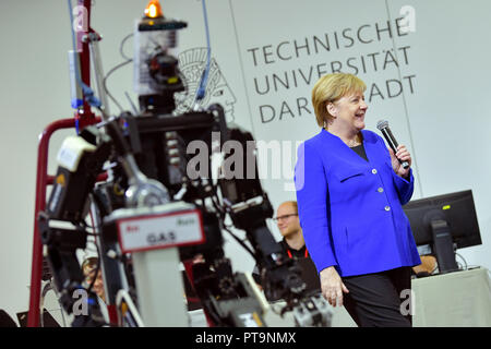 Darmstadt, Hessen, Germany. 08th Oct, 2018. Chancellor Angela Merkel (CDU) stands next to humanoid robot Johnny during a visit to the Technical University. During a demonstration, search and rescue robots from the 'Hector' team are used, which can, for example, search autonomously for buried people. Credit: Uwe Anspach/dpa/Alamy Live News Stock Photo