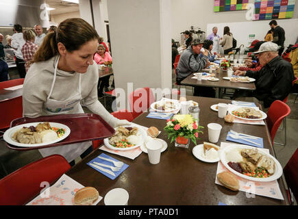 Vancouver, Canada. 8th Oct, 2018. A volunteer distributes dishes during the Thanksgiving Day dinner event in Vancouver, Canada, on Oct. 8, 2018. Vancouver's Union Gospel Mission?served 3,000 turkey meals to the homeless people and low income families during Canada's Thanksgiving Day which fell on Monday. Credit: Liang Sen/Xinhua/Alamy Live News Stock Photo