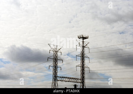 High voltage electrical power tower and cables on a partly cloudy day Stock Photo