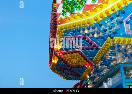 Amusement park. Beautiful bright building with burning lights close-up against the blue sky. Stock Photo