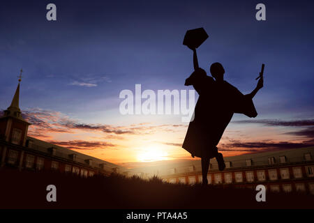 Silhouette of happy student woman celebrating graduation on campus Stock Photo