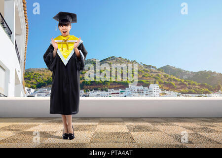 Happy asian student girl holding diploma scroll at graduation ceremony Stock Photo