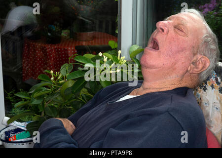 Elderly man asleep in conservatory
