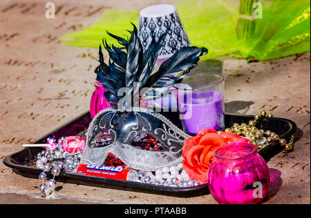 A tray of trinkets, including a Mardi Gras mask, are left at the base of Joan of Arc's statue, Nov. 15, 2015, in New Orleans, Louisiana. Stock Photo