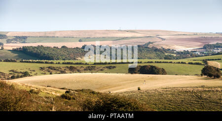 Woods and farmland fields cover the rolling landscape of the South Downs hills near Brighton in Sussex. Stock Photo