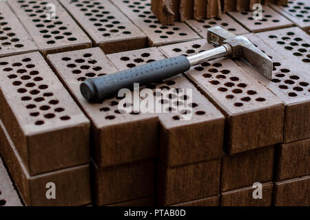 A hammer is laid on a red brick stack. Stock Photo