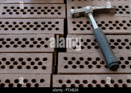 A hammer is laid on a red brick stack. Stock Photo