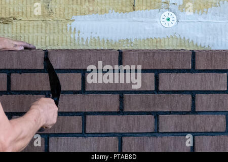 Bricklayer worker installing bricks on construction site. Stock Photo