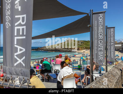 People sitting and relaxing eating and drinking at Porthmeor café bar on Porthmeor beach, St. Ives, Cornwall, England, UK Stock Photo
