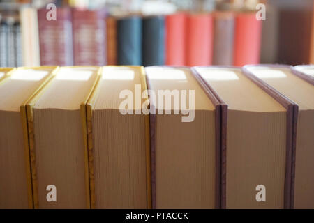 Backward books on the bookshelves. Books in the storage on the shelf, close up top view Stock Photo