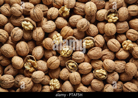 Walnuts with and without shells (filling the picture). Background of fresh walnuts. Stock Photo