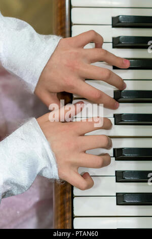 Children's hands on piano keys. vertical photo. Stock Photo