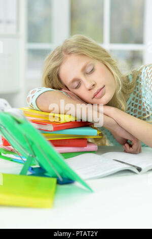 Portrait of tired schoolgirl sleeping at desk after studying at home Stock Photo
