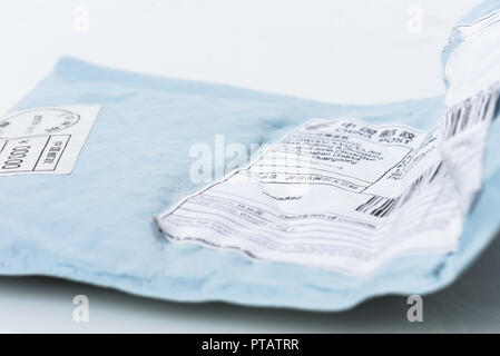 Postal package parcel sent from China with Customs declaration. Opened envelope from a shipment from China. Stock Photo