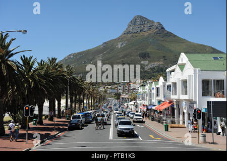 The seafront with its line of palm trees and boutiqe style shops and bars at Camps Bay, Cape Town South Africa Stock Photo