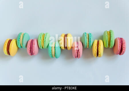 Sweet almond colorful pink, biue, yellow, green macaron or macaroon dessert cake isolated on white background. French sweet cookie. Minimal food bakery concept. Flat lay, top view, copy space Stock Photo