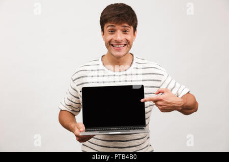 Image of excited man standing isolated over white background using laptop computer showing empty display. Stock Photo