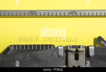 Old typewriter with yellow paper with text Merry Christmas Stock Photo