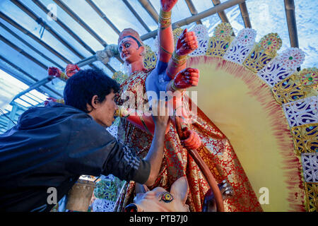 An artist decorates an idol of Hindu Goddess Durga, the matriarch of power and prosperity, ahead of The Dashain Festival.  Dashain is one the biggest festival celebrated by Hindu in Nepal, during this festival Nepalese sacrifice animal like goat, buffalo, sheep, hen and duck to offer and worship Hindu Goddess Durga and celebrate victory over evil. Stock Photo